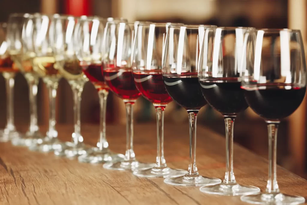 row of wine glasses with colors ranging from pale white on the left to dark red on the right