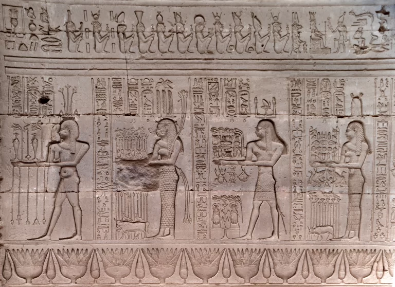 Egyptian heiroglyphs and images of people making wine Photo Credit: hemro/Shutterstock.com